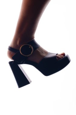  Beyaz arka planda yüksek topuklu kadın bacağı