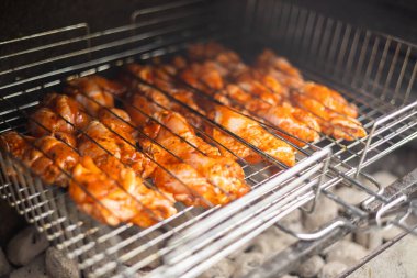 Izgarada marine edilmiş tavuk kanadı pişiriyorum.