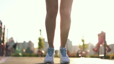 Sportif kadın atlama egzersizi yapıyor ve ip atlıyor.