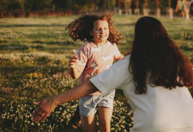 Bir çocuk parkta annesine doğru koşuyor. Anneler Günü