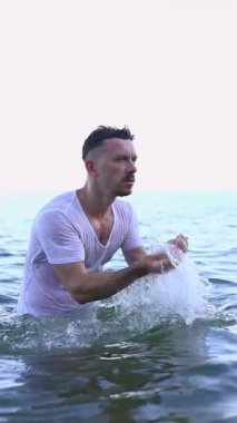 Genç adam denizde yüzmekten hoşlanıyor.