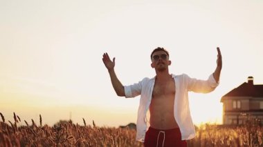 Genç adam günbatımında hayatın tadını çıkarıyor.