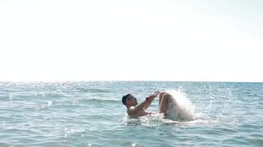 Genç adam denizde yüzmekten hoşlanıyor.