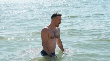 Genç adam denizde yüzmekten hoşlanıyor.