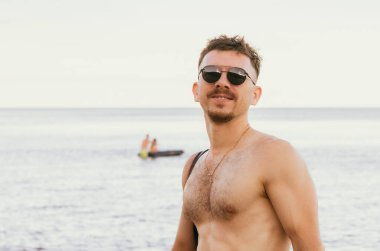 Genç bir adam denize karşı dinleniyor.