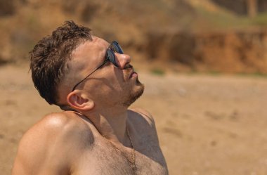 Genç adam sahilde tatilin tadını çıkarıyor.