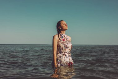 Denizde dikilen güzel elbiseli kadın.