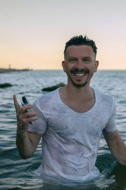 Yakışıklı bir adam ve okyanusa karşı parfüm