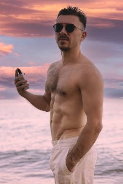 Genç bir adam ve bir şişe parfüm.