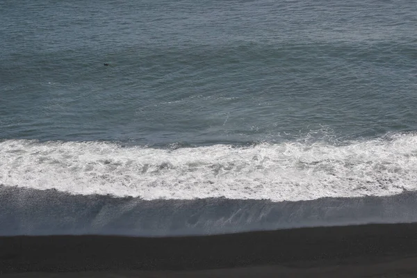 アイスランドのダイローレー島の黒砂のビーチで波がクラッシュ — ストック写真