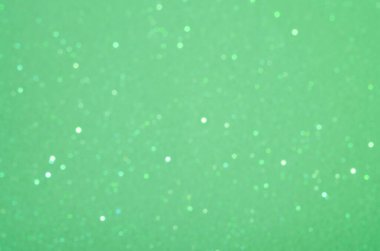 Açık yeşil arkaplan, bulanık küçük kıvılcımlarla.
