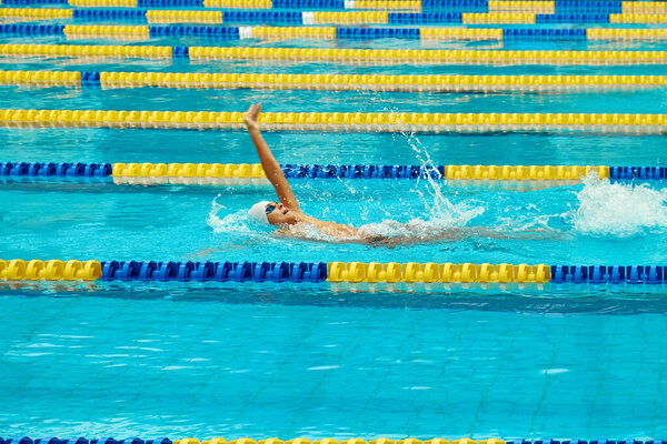Kyiv, Ukraine, 10.28.2023. Swimming competition at CSK ZSU sports complex. Turquoise swimming pool lanes, a symbol of sport and the Olympics. Backstroke style.