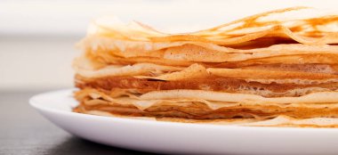 Kahverengi bir masada kızarmış krep ile yuvarlak bir tabak. Kahvaltıda tatlı bir tatlı. Güneşli sabah.