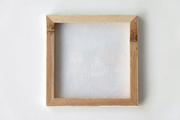 The reverse side of a canvas in a wooden frame on a white background. Preparation for painting.