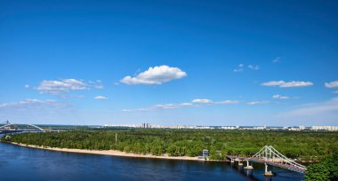 Dnipro Nehri 'nin panoramik manzarası ve Ukrayna' nın Kyiv kentindeki Trukhanov Adası 'na giden yaya köprüsü..