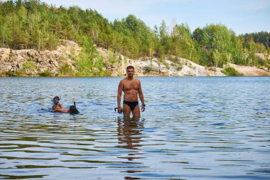 Göletten çıkan iki oğlu olan mutlu bir baba. Gölde çocuklu bir baba. Su altı maskeli çocuklar. Tatilde mutlu bir aile. Hafta sonları dinlen. Babalar günü..