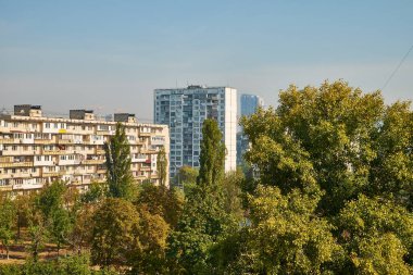 Kyiv. Ukrayna 09.20.2024. Açık gökyüzünün altındaki ağaçlarla çevrili Sovyet döneminden kalma apartmanlar ve bir okulun yer aldığı şehir manzarası, Doğu Avrupa 'da bir yerleşim bölgesinin özünü yansıtıyor.