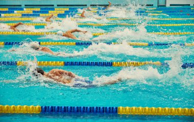 Turkuaz yüzme havuzu şeritleri, sporun sembolü. Sporcular serbest yüzer.