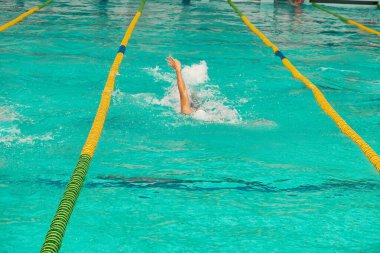 Turkuaz yüzme havuzu şeritleri, sporun sembolü. Spor kompleksinde yüzme yarışması. Sırt üstü yüzme.