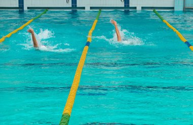 Turkuaz yüzme havuzu şeritleri, sporun sembolü. Spor kompleksinde yüzme yarışması. Sırt üstü yüzme.