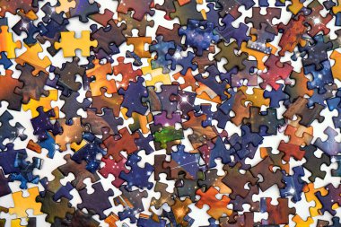 Beyaz arka planda parçalanmış yapboz parçaları. Kompozisyon tamamlanmamış bir bulmacayı gösteriyor.