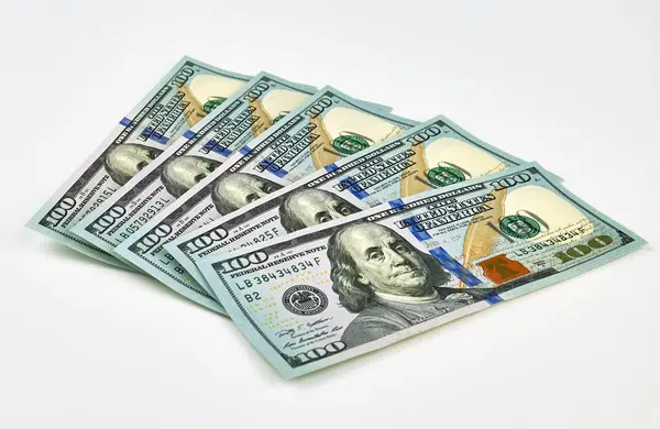 Beyaz arka planda yeni 100 dolarlık banknotlar serpiştirilmiş. Finans, zenginlik, tasarruf, bankacılık veya ekonomik başarı kavramı.