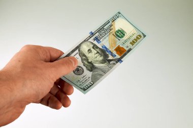 Erkek el yeni tasarlanmış 100 dolarlık bir banknot tutuyor. Ödeme, maaş, nakit işlem, finans, tasarruf, yatırım veya cömert bahşiş kavramı.