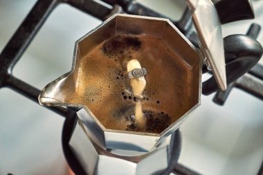 Moka demliğinin içinde gazlı fırının üstünde kaynayan taze kahve fincanı. Ağızdan yükselen Aromatik espresso zengin krema oluşturur..