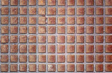 Paslanmış metal bir elmas plakaya yakın plan ve tekrar eden kare desenli. Arkaplan, grunge dokusu veya endüstriyel tasarım için ideal.