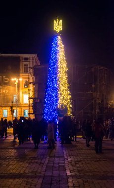Yazı işleri. Aralık, 2023. Kyiv, Ukrayna. Savaş sırasında Ukrayna 'da Kyiv' de mızraklı ve madalyalı bir Noel ağacı. Yeni yıl 2023. Kiev 'de bir Noel ağacında parlayan mızrak. Bohdan Khmelnitsy Anıtı bombardımandan korundu