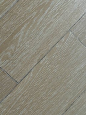 Doğal ahşap dokusunu içeren açık renkli lamine döşeme detaylı bir yakın plan. Görüntü, temiz çizgileri ve organik hissi yakalar., 