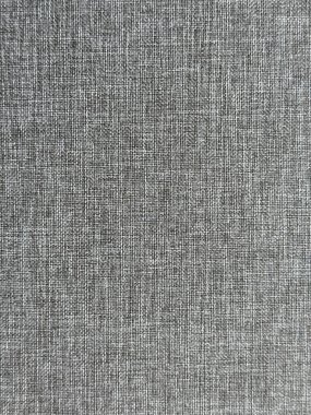 Gri kumaşın dokuma dokusunu gösteren bir makro çekim, genellikle döşeme, yastık ya da iç tasarım elementlerinde kullanılır..