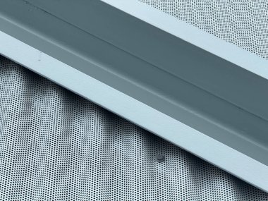 Endüstriyel metal yüzeyinin, delikli noktalar ve çelik kiriş detaylarıyla soyut arkaplanını kapatın. Mimarlık, inşaat, modern tasarım, endüstriyel doku ve yapısal elementler kavramı.