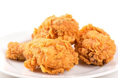 Kızarmış tavuk budu, beyaz bir tabakta.