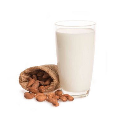 Beyaz arka planda izole edilmiş süt ve badem dolu cam bardak.