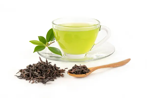 green tea with dry tea leaves and spoon on white.