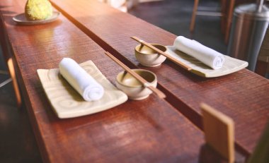 Geleneksel Japon restoranı, Asya usulü suşi ahşap bar tezgahı, menü, kase, cam peçete jenerik dekor boş kimse kapatmıyor.