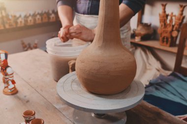Man molding clay to make ceramics with his hands in a crockery craft workshop, Artisan weaver working in his workshop, Ayacucho Peru