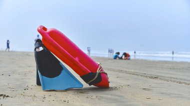 Young lifeguard with a rescue orange buoy. Security measures on the beach. lifesaver watching the situation on the sea clipart