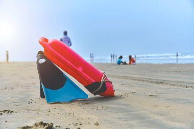 Kurtarma turuncu şamandırası olan genç bir cankurtaran. Kumsaldaki güvenlik önlemleri. Hayat kurtarıcı denizdeki durumu izliyor.