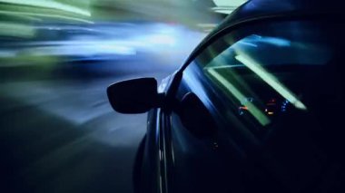 Yeraltı otoparkında biten büyük bir şehirde hızlı bir gece yolculuğunun zamanı. Gece vakti şehirde araba sürerken. Arabanın camındaki kamera..