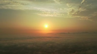 Hareket eden beyaz bulutlar hareket eden mavi gökyüzü manzaralı hava manzaralı gün doğumu. İHA, turuncu yaz güneşinde kabarık bulutların arasından mavi gökyüzünde geri uçar. Yüksek kalite 4k görüntü