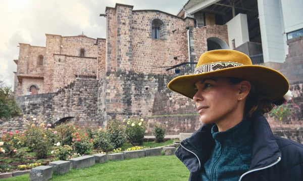 Cusco, Peru 'daki Qorikancha iç bahçelerini keşfeden şık bir turist. Tarihle doğanın büyüleyici bir karışımı..