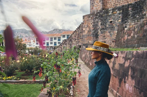 Cusco, Peru 'daki Qorikancha iç bahçelerini keşfeden şık bir turist. Tarihle doğanın büyüleyici bir karışımı..