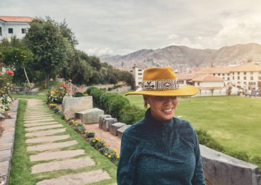 Cusco, Peru 'daki Qorikancha iç bahçelerini keşfeden şık bir turist. Tarihle doğanın büyüleyici bir karışımı..