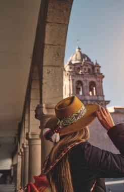 Cusco, Church ve Convent of San Francisco de Asis 'i gezen, şapka ve ruana takan mutlu bir kadın.