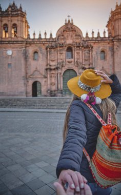 Cuzco 'nun ana meydanında el ele tutuşan bir çift. Peru.