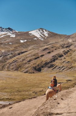 Gökkuşağı Dağı 'na giden Vinicunca Patikası' nda turistik destek için atı olan bir işçi. Andes Cordillera 'daki Cerro Colorado Vadisi' nde yaşayan geleneksel insanlar..