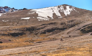 At sırtında at süren yerli rehber geleneksel kıyafetlerle gezintiye çıkıp renkli Rainbow Mountain Vinicunca 'ya ya da Peru, Güney Amerika yakınlarındaki Winikunka' ya gidiyor..