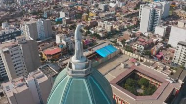 Lima, Peru 'daki bir kilisenin insansız hava aracı görüntüsü. Magdalena del mar bölgesinde, Bakire Meryem heykeli ve kamera ile kubbe, ufukta birçok bina ve okyanusu gösteriyor.